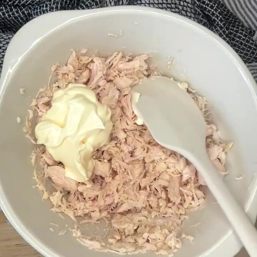 Flaked canned chicken with mayonnaise dressing being added to it