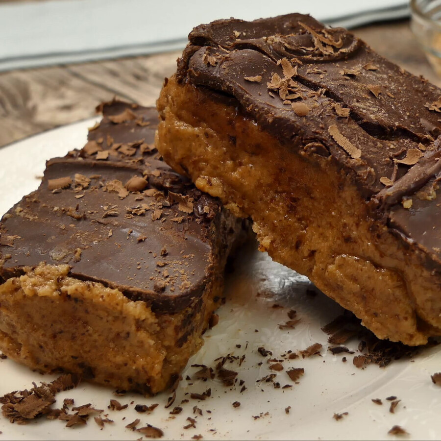 Sliced keto peanut butter bars on a cooking surface stacked on top of eachother