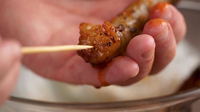 Side shot of placing the shrimp on a skewer.