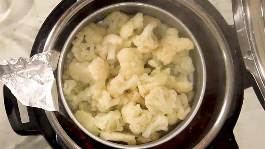 Overhead shot of removing steamed cauliflower from the Instant Pot.