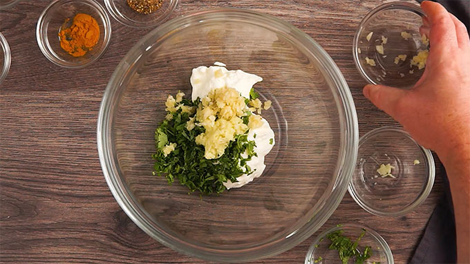 overhead shot of bowl with yogurt ginger garlic and cilantro to make chicken tikka kababs