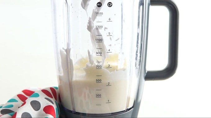 Side shot showing 1 Adding lemon juice, extract, and sour cream to a blender