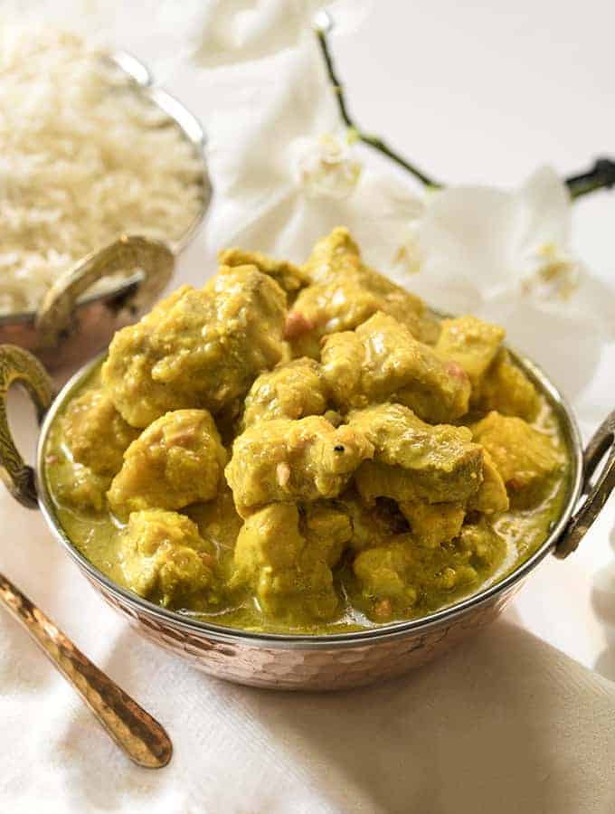 Instant pot chicken korma sideways view with rice in the background