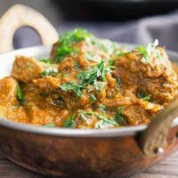 side view of lamb curry in small brass wok
