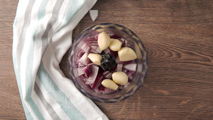 overhead shot on onions and garlic in a food processor bowl