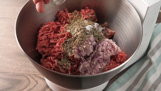 Meat and seasonings in the bowl of a stand mixer