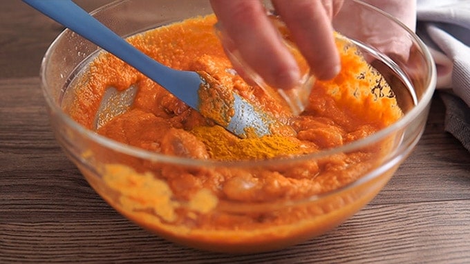 Side shot of adding the turmeric to the chicken vindaloo sauce.