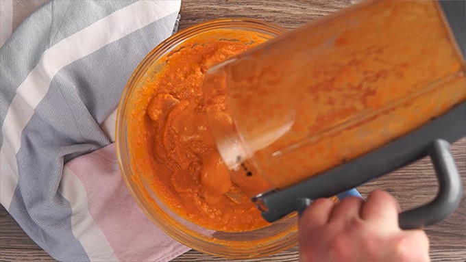 Overhead shot of coating the chicken with the vegetable and spice mixture.