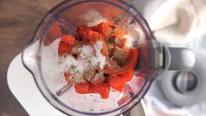 Overhead shot of the veggies and seasonings (except for the turmeric) added to the blender.