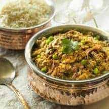 Instant Pot Kheema in small brass pot with rice at the back sideways view