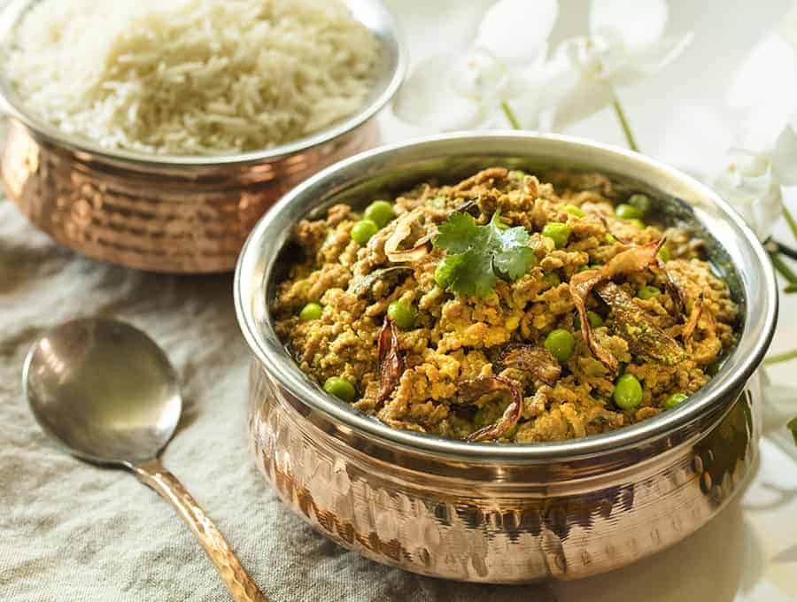 Instant Pot Kheema in small brass pot with rice at the back sideways view