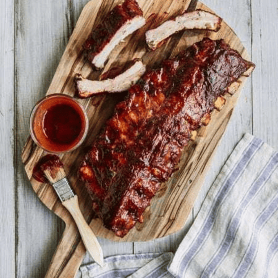 Smoked Ribs on a cutting board with sauce