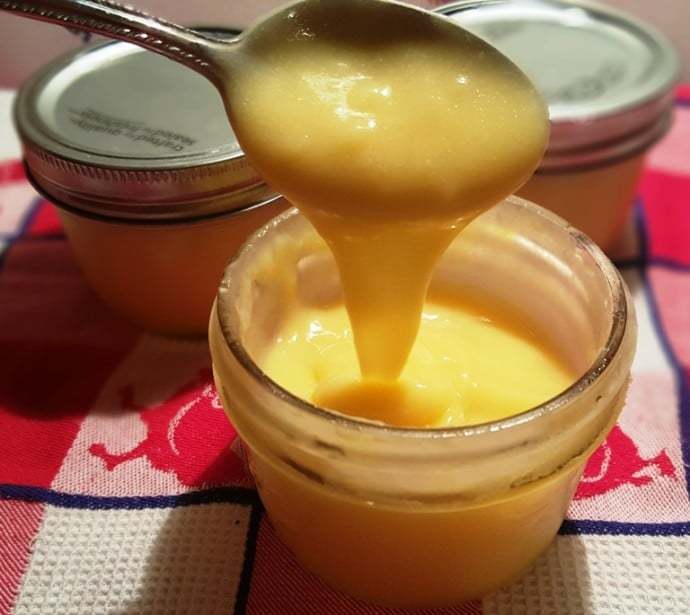 A cup of Lime Curd with a spoon.