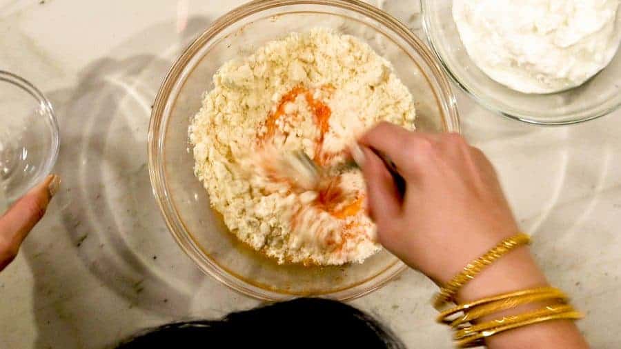 Overhead shot of adding unflavored way powder to mixing bowl.