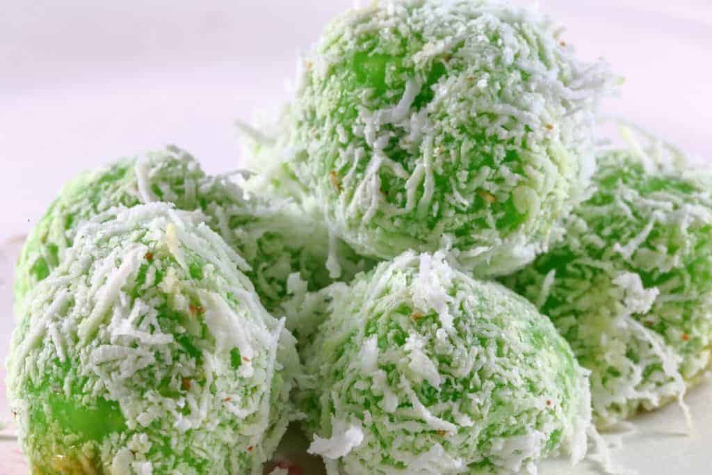 Selection of green ondeh ondeh balls piled on top of each other. Bite into the perfect mix of pandan and coconut, Nyonya Ondeh Ondeh, and serve a dessert the whol