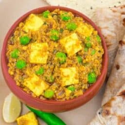 matar paneer in a red bowl