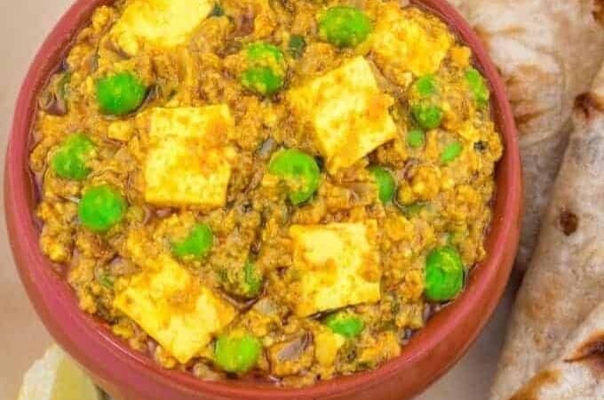 matar paneer in a red bowl