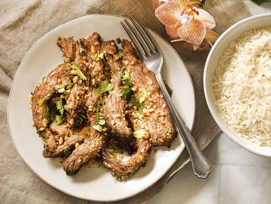 Air fried Beef Satay on a white plate overhead shot