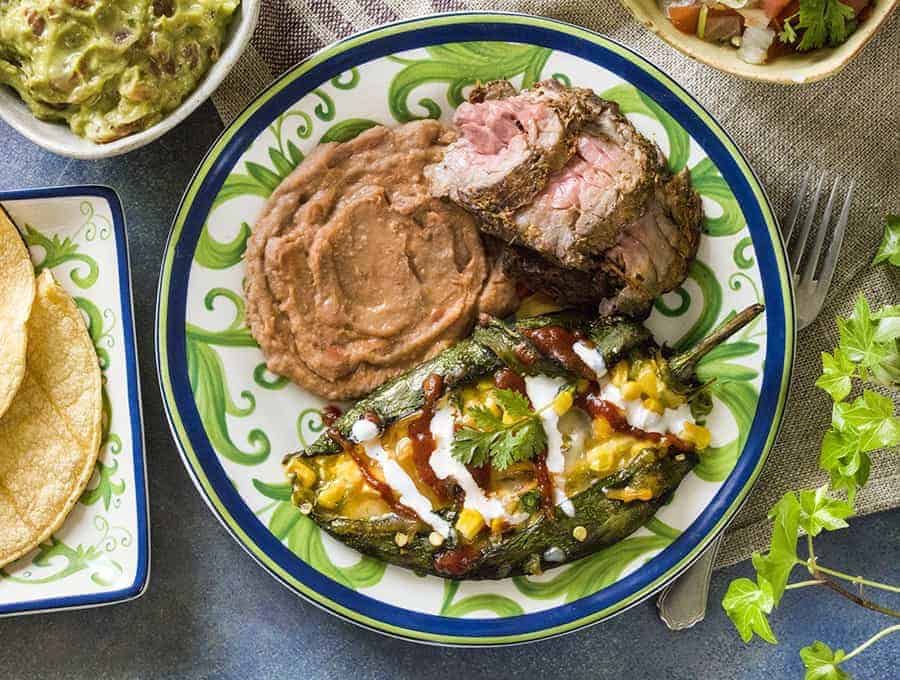 Air Fryer Chile Rellenos overhead view with carne asada and refried beans on a plate