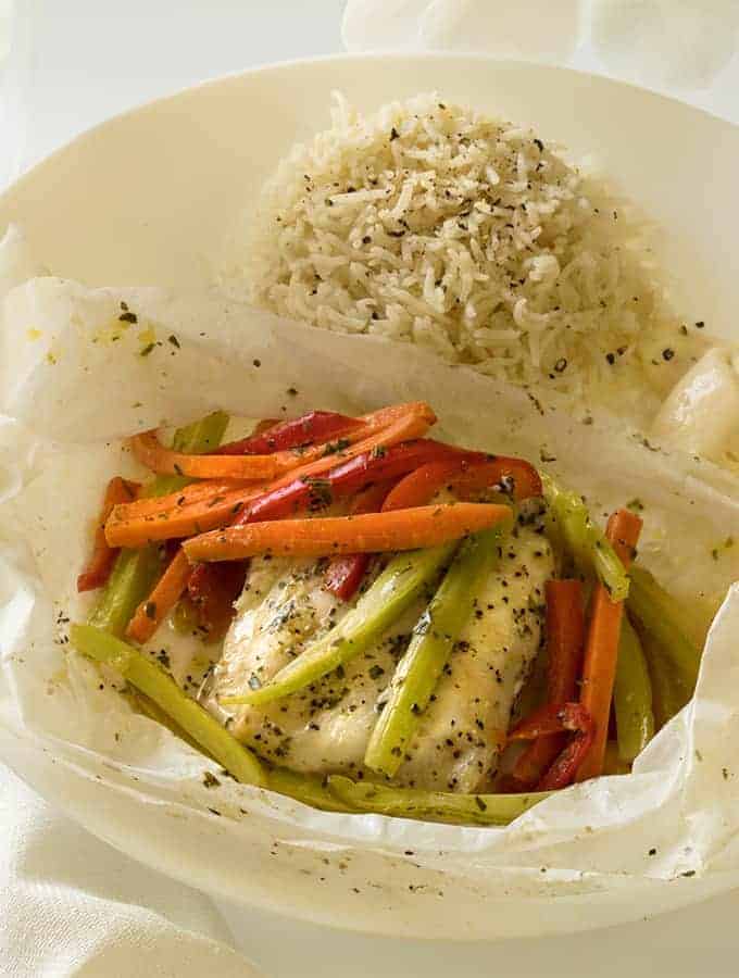 Fish en Papillote with vegetables on top and rice on the side