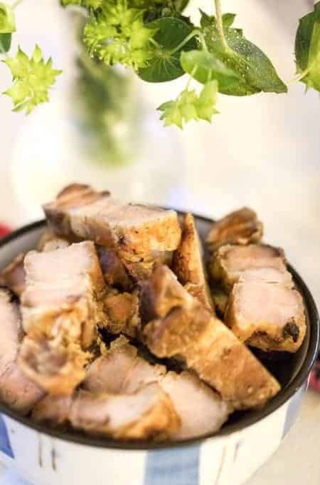 Pork Belly made in the Instant Pot and Air Fryer in a bowl with greenery in the background