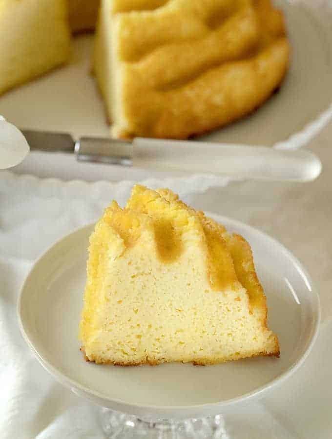 Cream Cheese Pound Cake, Keto Friendly on a white dish being cut by a knife