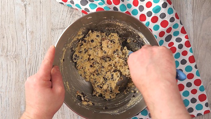 Overhead shot of folding the chocolate chips and nuts into the mixture.