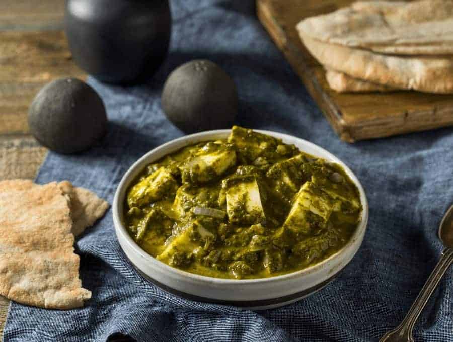 Uma tigela de Palak Paneer sobre uma mesa.