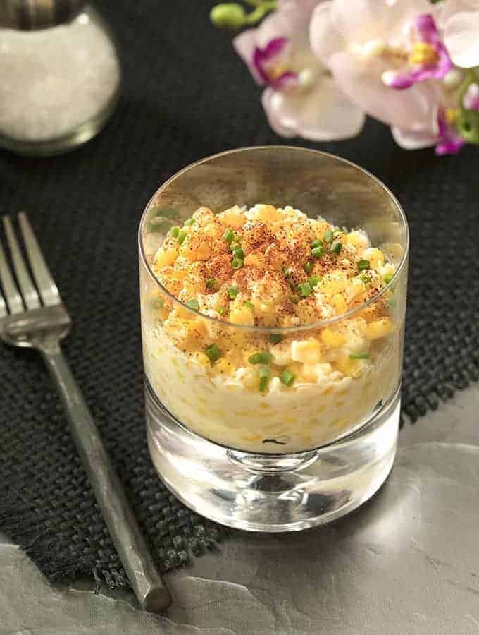 A bowl of corn chowder on a table.