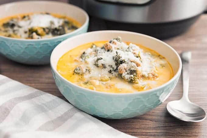 Instant Pot Italian Sausage and Kale Soup with Parmesan cheese served in a bowl with a spoon