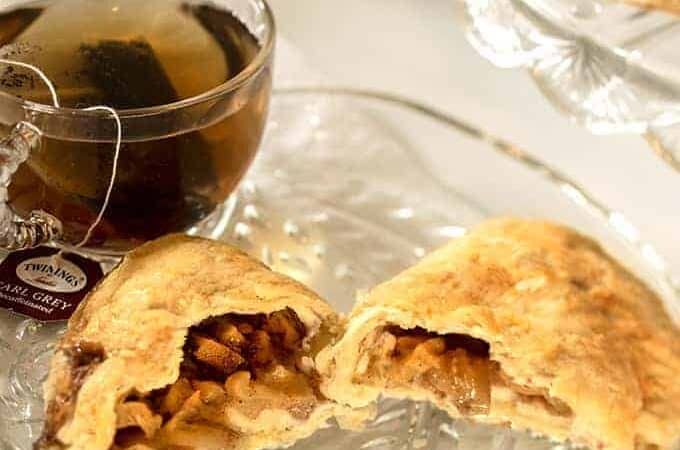 Apple Hand Pies on a Glass Platter with a cup of Tea