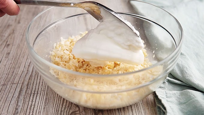 Egg white and Swerve mixed together being placed in a glass bowl of dry ingredients.
