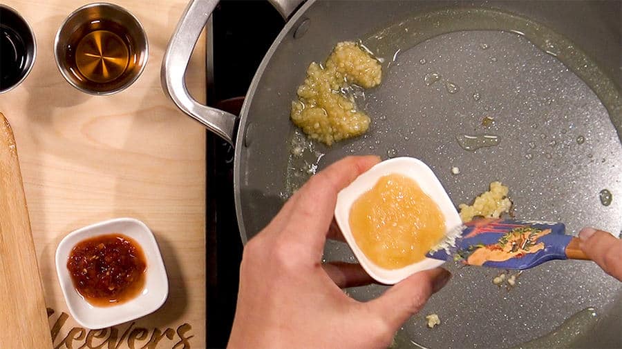 To the hot oil, add ginger and garlic, and ground meat To the hot oil, add ginger and garlic, and ground meat