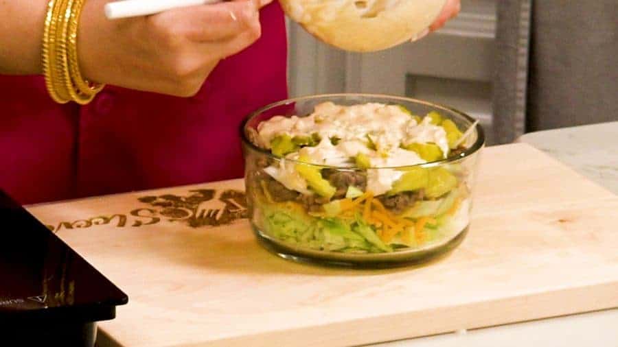 Adding toppings to the almost finished salad