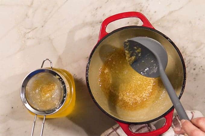 Overhead shot of the ghee being strained from the cooked butter.