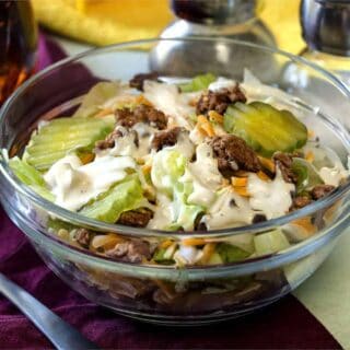 big mac salad low carb hamburger salad in a glass bowl with pickles and dressing on top