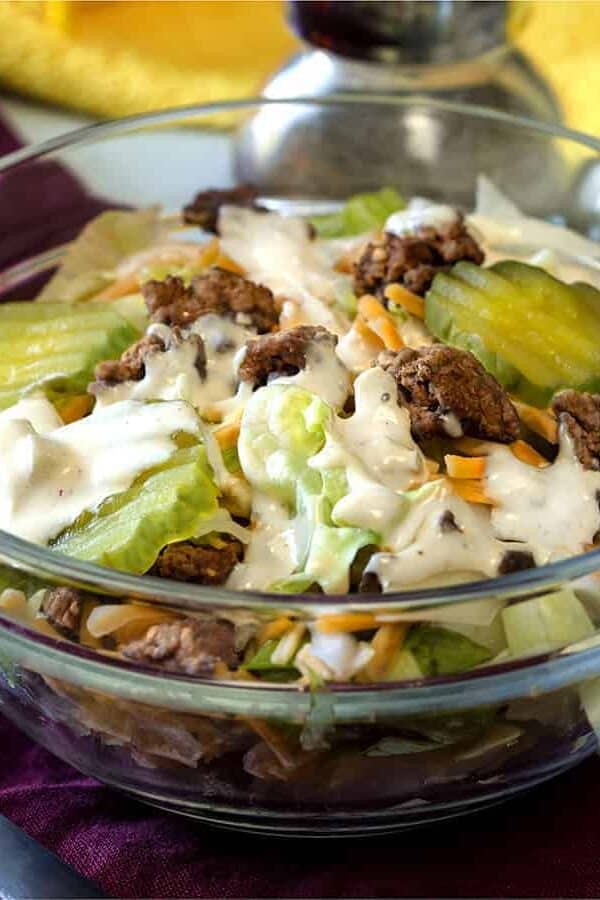big mac salad low carb hamburger salad in a glass bowl with pickles and dressing on top