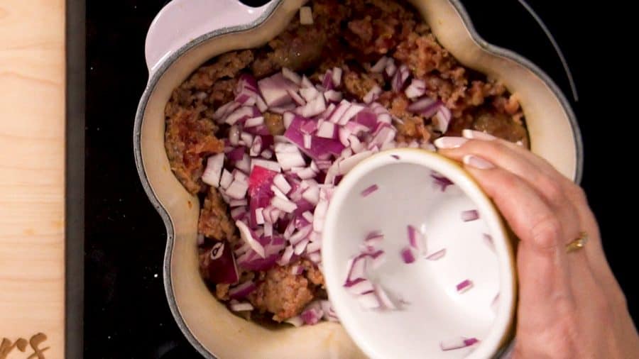 Adding onions and garlic to the sausage.