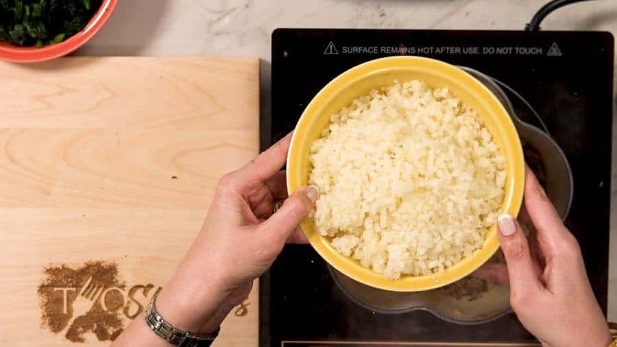 Overhead shot of riced cauliflower in yellow bowl
