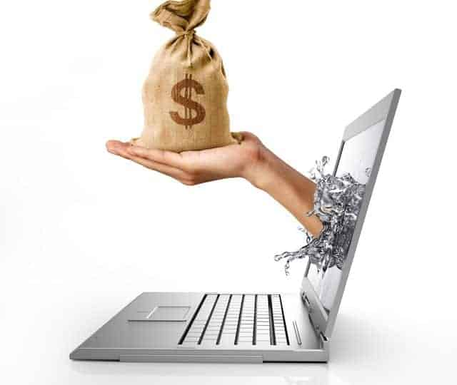 Man's hands, splashing out from a computer laptop screen, holding a bag of US Dollars money on it. On white background, with clipping path included.