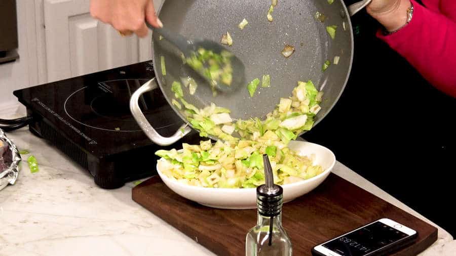Side view of removing onions and cabbage to a serving dish.