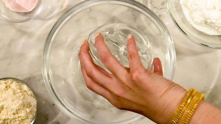 Overhead shot of adding warm water to mixing bowl.