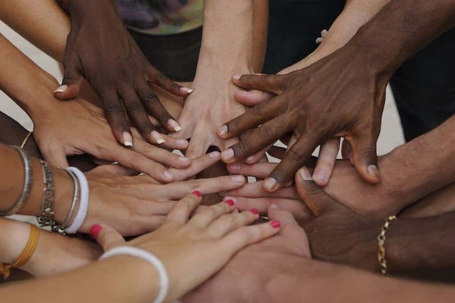 Many hands together: group of diverse people joining hands