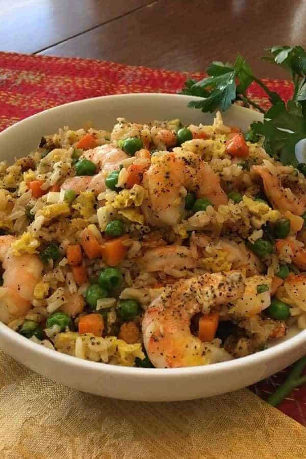 Air Fryer Shrimp with peas and carrots in a white bowl.