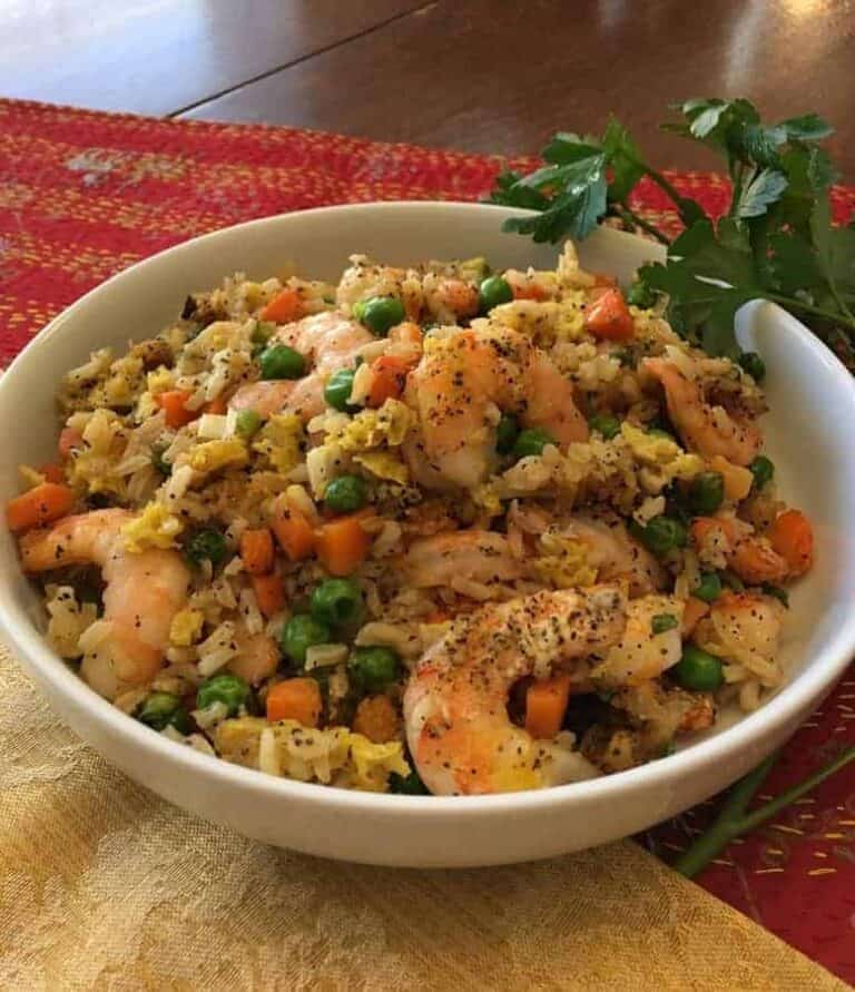 Air Fryer Shrimp with peas and carrots in a white bowl.