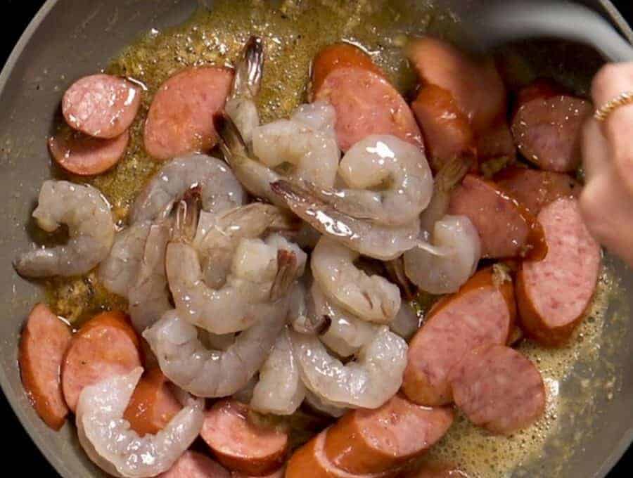Overhead shot of stirring the shrimp and sausage.