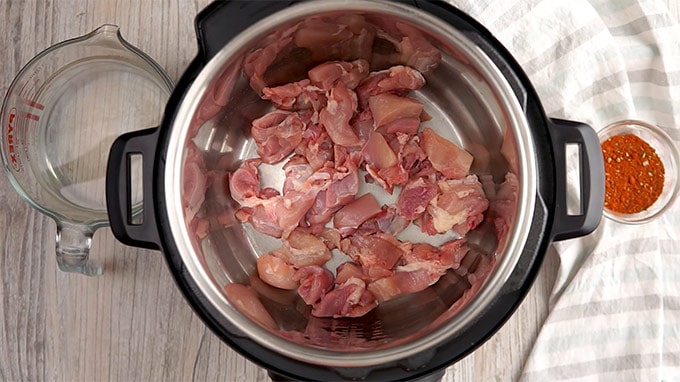 Boneless Skinless Chicken thighs chopped and placed in the inner liner of an Instant Pot. 