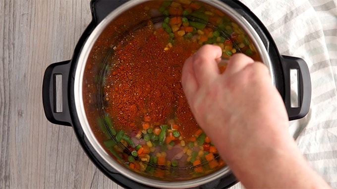 2 قاشق غذاخوری چاشنی مکزیکی در سبزیجات منجمد و آب در آستر داخلی سوپ تاکو مرغ فوری.