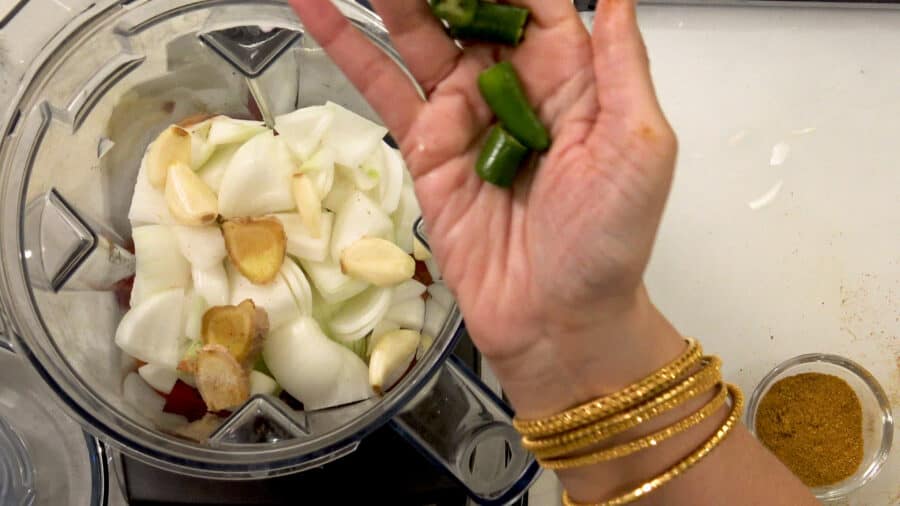 A person holding ingredients for Slow Cooker Chana Masala.