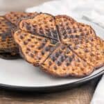Two chocolate chaffles on a white plate sideways